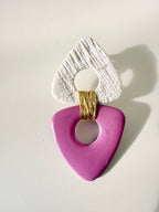Close-up of a handcrafted pink polymer clay statement earring with textured white clay and gold wire detail by Aygem Art Studio.
