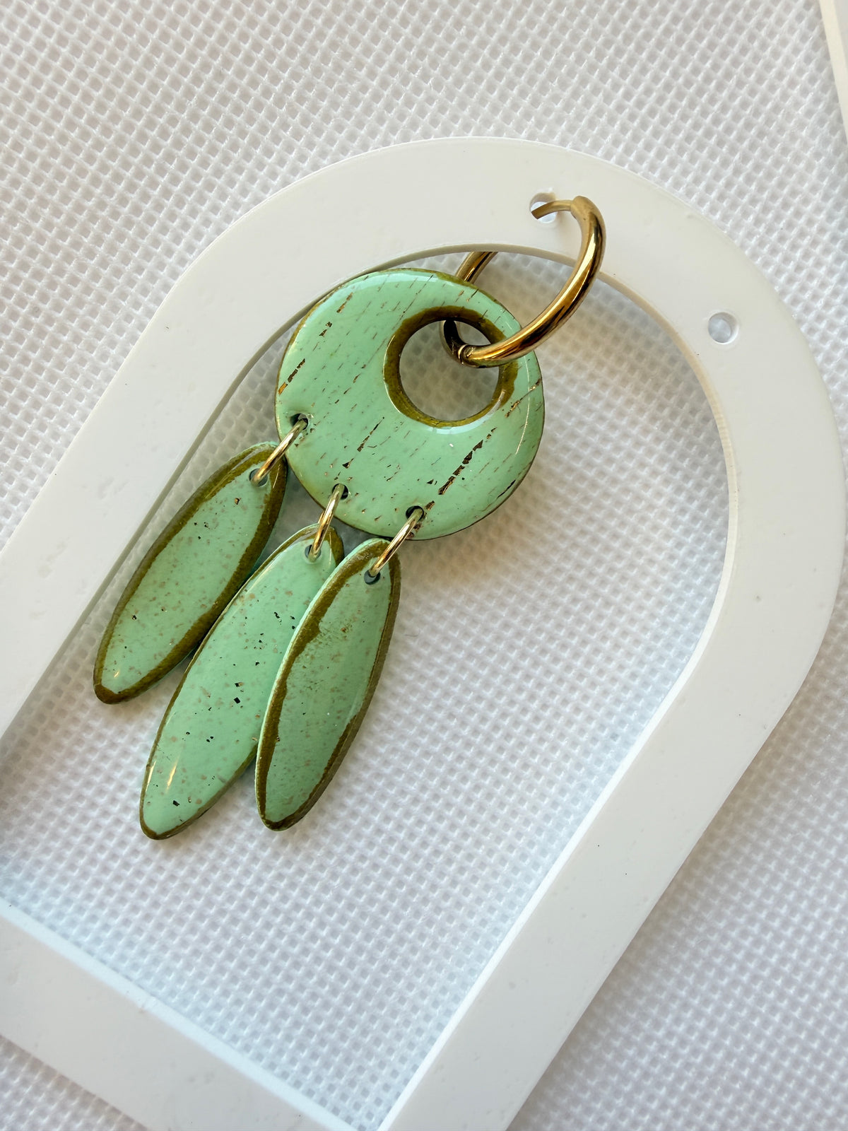 Willow Mint polymer clay statement earring with three speckled mint drops, styled on a white arch tray